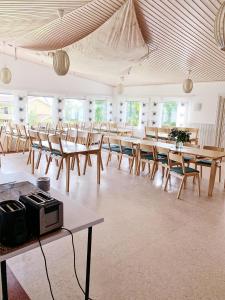 a large room with wooden tables and chairs at Övernäsgården Gästhem in Mariehamn