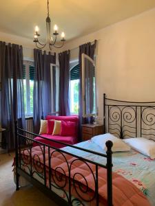 une chambre avec un lit et un canapé rouge dans l'établissement Villa CorteOlivo Rooms, à Torri del Benaco