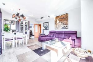 マドリードにあるBonito piso luminoso en urbanización de lujoの紫色のソファとテーブル付きのリビングルーム