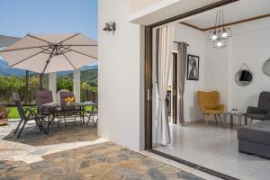 a living room with a table with an umbrella at Aphrodite's house in Alikianós