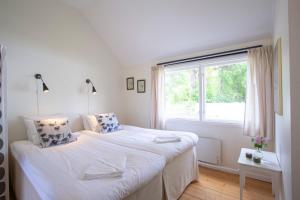 HällevikにあるHälleviks Havsbadの白いベッドルーム(ベッド1台、窓付)