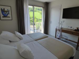 ein Schlafzimmer mit einem großen weißen Bett und einem Fenster in der Unterkunft Cit'Hotel Grand Hotel L'Etape in Saint-Flour