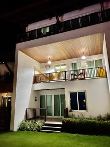 ein weißes Haus mit einem Balkon und einem Hof in der Unterkunft Apartamento no Club Meridional in Praia dos Carneiros