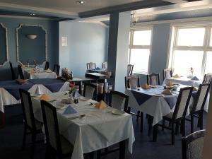 a dining room with tables and chairs with white table cloth at Glen Orchy House in Lerwick