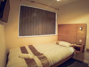 een slaapkamer met een groot bed en een raam bij Hallam Rooms in Boston