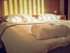 een bed met twee kussens en handdoeken erop bij Hallam Rooms in Boston