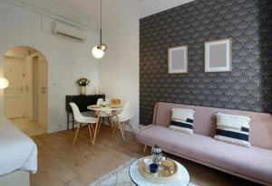 a living room with a pink couch and a table at HolidaysInParis - Republique in Paris