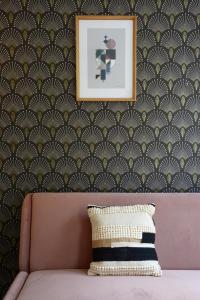 a couch in front of a wall with a picture at HolidaysInParis - Republique in Paris