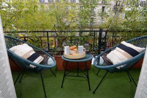 a balcony with two chairs and a table with a bowl on it at HolidaysInParis - Republique in Paris