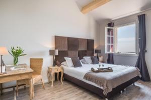 a bedroom with a bed and a desk and a window at Histoires de Bastide in Tourrettes-sur-Loup