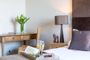 Un dormitorio con una cama y una mesa con una copa de vino en Histoires de Bastide, en Tourrettes-sur-Loup