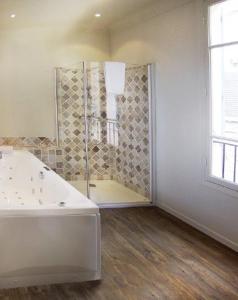 uma casa de banho branca com uma banheira e uma janela em Histoires de Bastide em Tourrettes-sur-Loup
