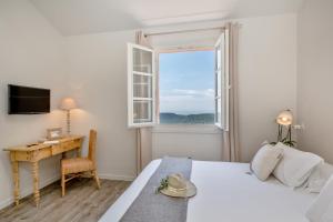 1 dormitorio con cama, escritorio y ventana en Histoires de Bastide, en Tourrettes-sur-Loup