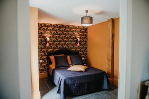 um quarto com uma cama num quarto com uma parede em La Maison Augustine em Gap