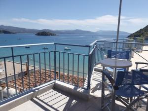 een balkon met een tafel en stoelen en de oceaan bij Dolfin in Tolo