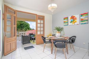 comedor con mesa y sillas en Le Brin d'Amour Apartment, en La Trinité