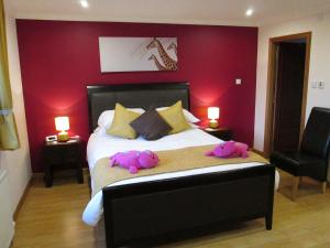 two stuffed animals laying on a bed in a bedroom at Broomlea in Ardersier