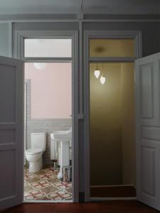 a bathroom with a toilet and a window and a door at Apartamento Torreón de la Bombardera in Teruel