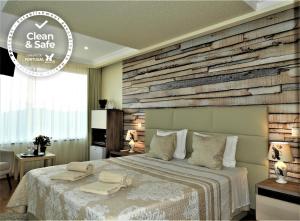 - une chambre avec un lit et un mur en bois dans l'établissement Hotel Rural Rocha da Gralheira, à São Brás de Alportel