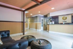 a lobby with couches and tables and a bar at Hotel Consentido in Granollers