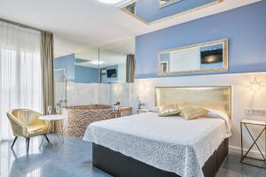 um quarto com uma cama grande e uma casa de banho em Hotel H em Granollers