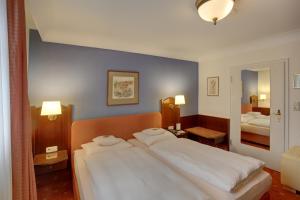 a bedroom with a large white bed with two pillows at Hotel Brauereigasthof Landwehr-Bräu in Reichelshofen