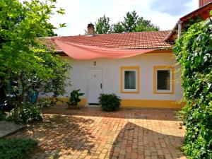 una casa con techo rojo y entrada de ladrillo en Brindza Vendégház, en Szeged