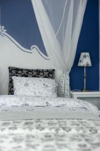 Dormitorio azul con cama con colcha blanca en Wijnstaete en Lemelerveld