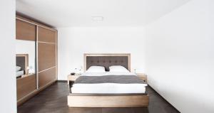 1 dormitorio con 1 cama grande y espejo en Isiliving, en Montabaur