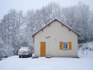 un coche aparcado frente a una casa en la nieve en chalet jennifer, en Laveissière
