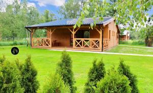 a small wooden cabin in a field of green grass at Domki w Lipnicy in Lipnica