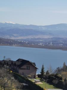 una casa en una colina junto a un cuerpo de agua en Ośrodek Wypoczynkowy Nad Jeziorem, en Żywiec