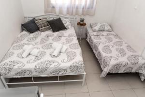 1 dormitorio con 1 cama con sábanas y almohadas blancas en סטודיו ליה - studio lia eilat, en Eilat