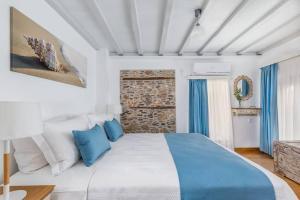 1 dormitorio con 1 cama grande con detalles en azul en Myrtia House Skopelos en Skopelos Town