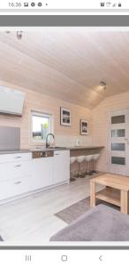 a kitchen with white cabinets and a table at Azalia 32 Mielno l in Mielno