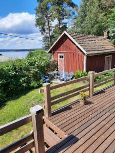 a wooden deck with a picnic table and a building at Punavilla majoitus TASANKO in Säkylä
