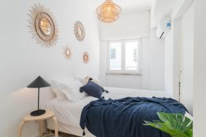 a bedroom with white walls and a bed with blue sheets at Casa Boma Lisboa - Architect Apartment with Private Terrace - Alcantara III in Lisbon