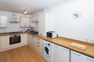 een keuken met een wasmachine en droger op een aanrecht bij Glasgow City Flats - Merchant City in Glasgow
