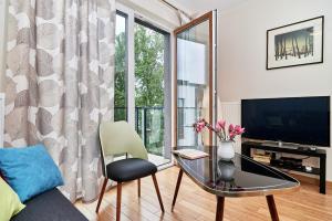 Televízia a/alebo spoločenská miestnosť v ubytovaní Exclusive Apartments Marina by Noclegi Renters