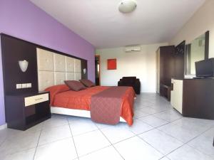 a bedroom with a bed and a flat screen tv at Sidari Waterpark in Sidari