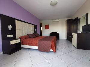 a bedroom with a bed and a tv in it at Sidari Waterpark in Sidari