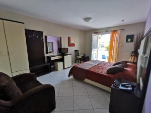 a bedroom with a bed and a desk and chairs at Sidari Waterpark in Sidari