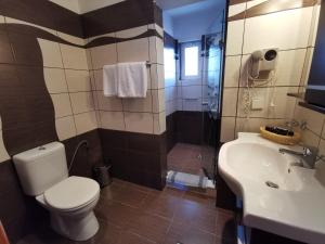 a bathroom with a toilet and a sink and a shower at Sidari Waterpark in Sidari