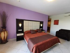 a bedroom with a large bed with a purple wall at Sidari Waterpark in Sidari
