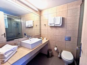 a bathroom with a sink and a mirror and a toilet at Sidari Waterpark in Sidari