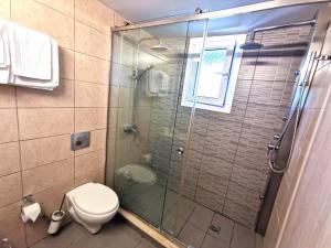 a bathroom with a toilet and a glass shower at Sidari Waterpark in Sidari