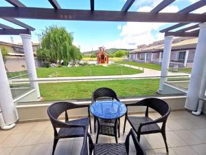 a table and chairs on a porch with a view of a yard at Sidari Waterpark in Sidari