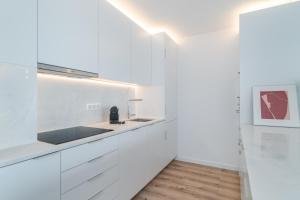 a kitchen with white cabinets and a sink at Casa Boma Lisboa - Architect Apartment with Private Terrace - Alcantara III in Lisbon +39 photos
