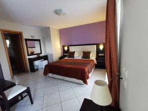 a hotel room with a bed and a chair at Sidari Waterpark in Sidari