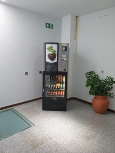 una máquina expendedora en una habitación con una planta en Mesón Hostal La Cabaña, en Medellín
